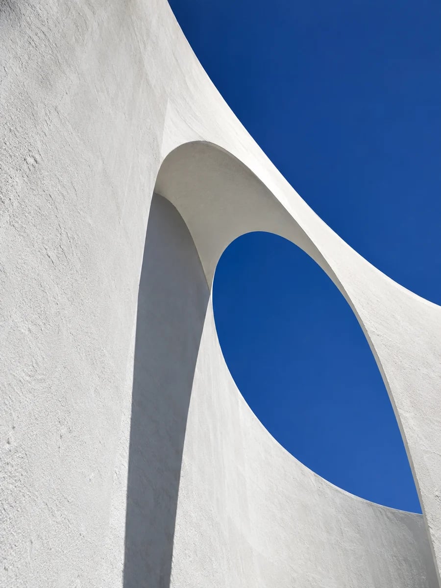 Curved white architecture against a blue sky